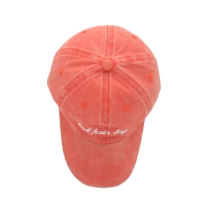 Detail of coral red washed cotton baseball cap featuring bad hair day embroidery