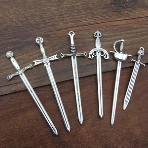 Detailansicht von sechs Vintage-Silberschwert-Anhängern mit Gladiator-Gravur auf Holz