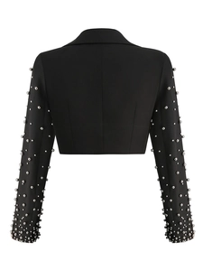 Detail of black fitted blazer featuring intricate silver beaded sleeves on white background