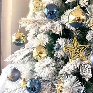 Close-up of blue and gold Christmas balls with reindeer and snowflake patterns