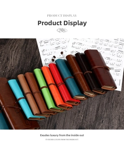 Close-up of vintage leather journals with leaf pendants and rustic tie-string closures