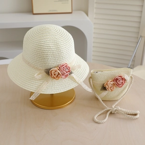 Detail of children's straw hat and matching bag with floral lace and ribbon accents