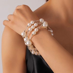 Gros plan détaillé d'un collier à trois rangs de perles d'imitation et entretoises en métal