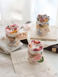 Detail showing cylindrical handmade scented candles with dried flowers and hemp rope decor