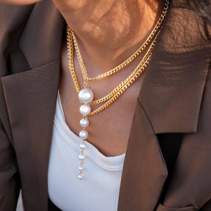 Detail of layered gold necklace with elegant cascading white faux pearl fringe pendant