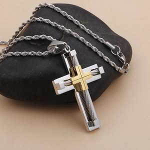 Detail of silver stainless steel cross pendant with gold inset and braided wire core