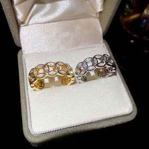 Close-up of gold and silver open rings with clear zircon crystals on velvet display