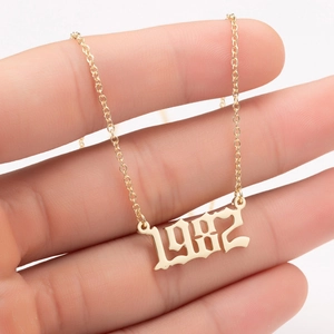 Detailed close-up of a golden gothic 1982 year necklace pendant held in hand