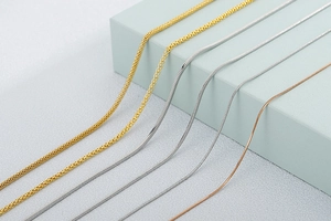 Détail de chaînes serpent et tissées en acier inoxydable or, argent et rose
