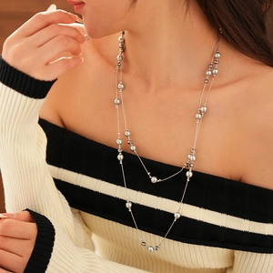 Detail of elegant silver-gray double-layered beaded necklace on woman's neck