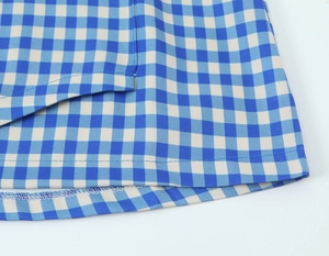 Detailed close-up of blue and white plaid fabric texture with neat double-stitched seams