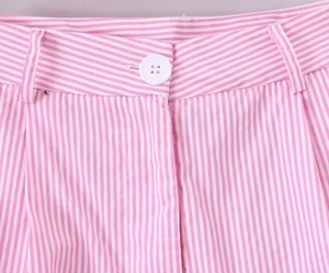Dettaglio della vita dei pantaloni a righe bianche e rosa con bottone e tessuto