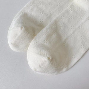 Macro shot of breathable pointelle knit mesh and seamless toe on white cotton socks