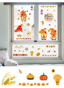 Close-up of autumn gnomes, pumpkins and maple leaf decals for window decoration