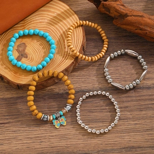 Detail of 5-piece bohemian beaded bracelet set with turquoise, wood beads and butterfly charm