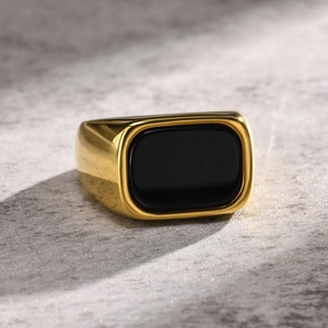 Macro shot of men's gold plated stainless steel ring with a large black rectangle stone