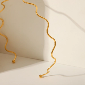 Detailed view of 18K gold plated wavy steel necklace with adjustable slide and bead ends