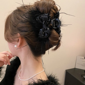 Elegant back view of black sequin feather bow hair claw clip styled on a woman's hair