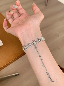 Close-up of a silver floral lace bracelet with crystal petals worn on a wrist