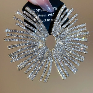 Macro shot of oversized round silver earrings with radiant pavé white rhinestones