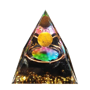 Orgone crystal pyramid with citrine ball and copper coil on a clean white background