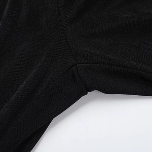 Detailed macro view of reinforced stitching on black backless bodysuit fabric