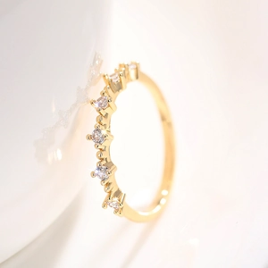 Vista macro lateral de un elegante anillo dorado con filas de circonitas brillantes