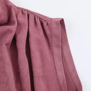 Détail en gros plan du tissu suédine mauve avec plis aux épaules et coutures précises