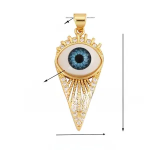 Macro detail of gold Evil Eye charm with zircons and size dimensions 30mm by 15mm