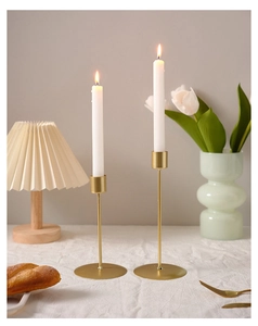Detail of matte gold metal candle holders in different heights for home table decor