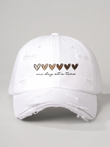 Close-up detail of white distressed baseball cap with heart print and text