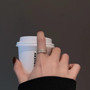 Detailed view of a layered gold ring with micro-pave zircons and white enamel finish