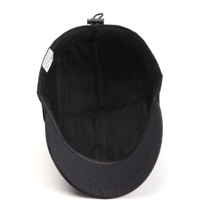 Internal view of black quick-dry cap showing breathable mesh lining and 100% polyester label