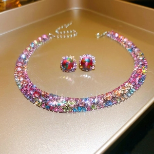 Close-up of a luxury vintage jewelry set featuring vibrant teardrop rhinestones on a gold tray