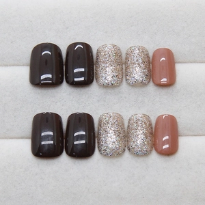 Brown shimmer press-on nails set with glitter and glossy finish on a display tray