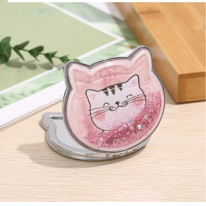 Close-up of pink cat-shaped folding makeup mirror with flowing liquid pink glitter