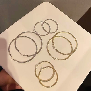Close-up of assorted gold and silver hoop earrings with sparkling rhinestone finish