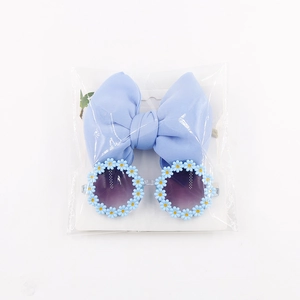 Close-up of light blue daisy sunglasses and matching hollow bow headband set for kids