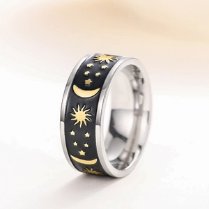 Macro detail of wide black enamel ring with golden celestial sun, moon and star motifs