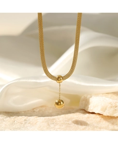 Detailed close-up of a 14K gold spherical pendant on a delicate woven stainless steel chain