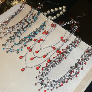 Close-up of vintage layered necklaces with pearls and colorful crystals on a velvet tray