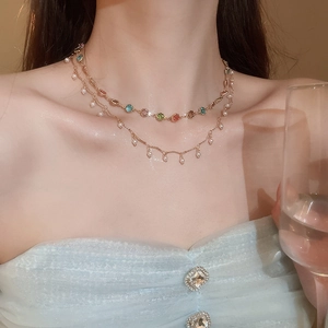 Detail einer zweilagigen Goldkette mit bunten Edelsteinen und hängenden Perlen