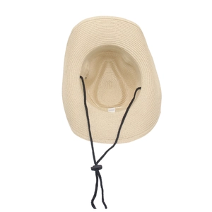 Inner view of a beige bohemian straw hat with adjustable black chin strap and sweatband