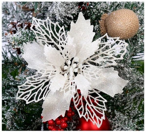 Gros plan d'un poinsettia de Noël blanc scintillant sur un sapin décoré de fêtes