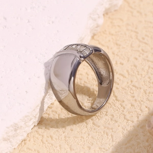 Detail of silver wide band ring featuring a single row of rectangular zirconia stones