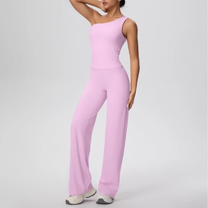 Détail du haut de yoga rose clair à une épaule et du pantalon large sur le mannequin