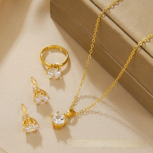 Detail view of a 4-piece jewelry set with sparkling round zircons in golden finish