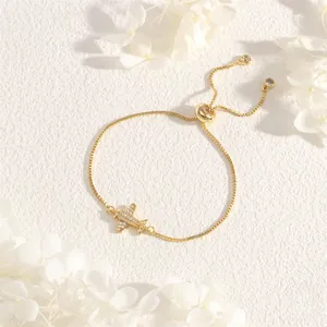 Detail of gold plane bracelet featuring zircon embellishments and adjustable box chain