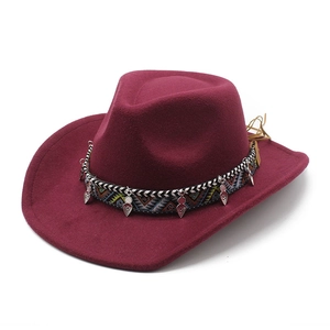 Détail du chapeau en laine bordeaux avec ruban ethnique et pendentifs en argent