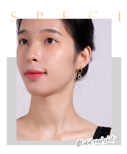 Close-up of model wearing gold heart circle earrings with sparkling cubic zirconia inlay